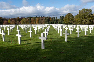 Fototapeta na wymiar Neupre, Belgium - November 1, 2021: Ardennes American Cemetery and Memorial. Many of the burial are from the Ardennes winter offensive (Battle of the Bulge). Autumn sunny day. Selective focus.