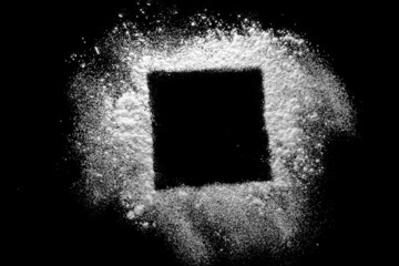 Flour is scattered from a bowl on a black table. top view.