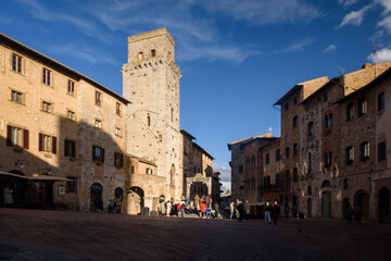 Fototapeta premium Geschlechtertürme, San Gimignano, Toskana, Italien bei Himmel mit Wolken und Sonne und Schatten.
