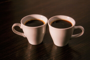 Two white cups of espresso on the table