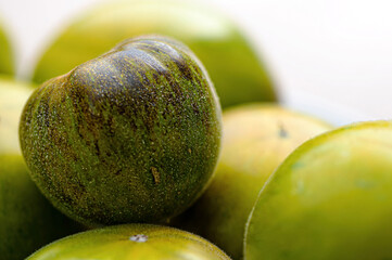 fresh and delicious tomatoes of green-black colored sort on a wooden table, closeup