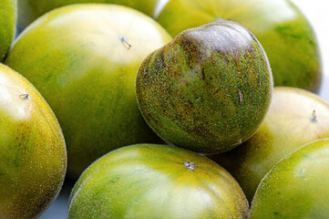 fresh and delicious tomatoes of green-black colored sort on a wooden table, closeup