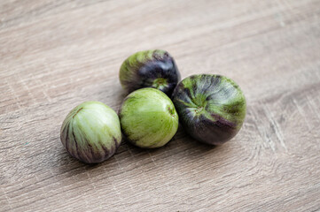 fresh and delicious tomatoes of green-black colored sort on a wooden table, closeup
