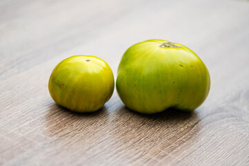fresh and delicious tomatoes of green colored sort on a wooden table, closeup