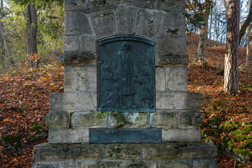 Fr&ouml;bel Denkmal in Keilhau in Th&uuml;ringen im Herbst umgeben von braunen Buchenbl&auml;ttern