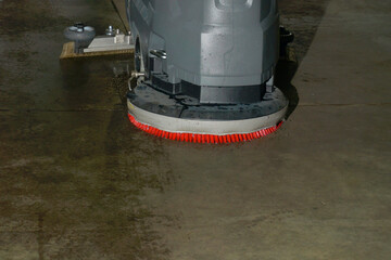 Scrubber drier on a concrete floor in action. Mechanical cleaning of premises.