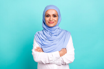 Photo of cute confident young lady dressed islamic hijab smiling arms crossed isolated teal color...