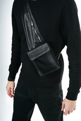 A man puts on a shoulder leather bag and advertises its appearance close up. mockup bag              