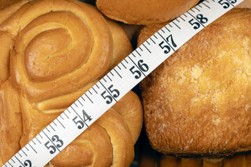 Calories counting. Inch measuring tape on sweet bakery buns. Measuring tape over pastry buns close-up. 