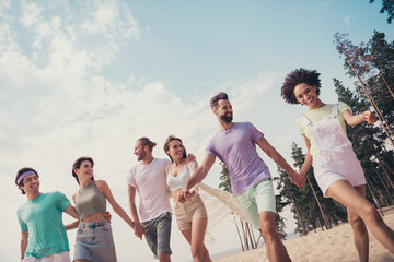 Photo of six funny dream friends group people hold hands stroll wear casual outfit nature summer seaside beach