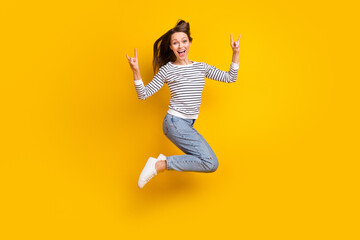 Fototapeta na wymiar Full size photo of carefree brunette millennial lady jump show rock wear jumper jeans shoes isolated on yellow color background