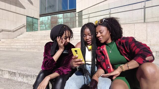 Happy black women taking selfie on street
