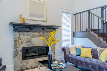 Beautiful and large living room interior with hardwood floors and vaulted ceiling in new luxury home. View of entryway, and second story loft style area