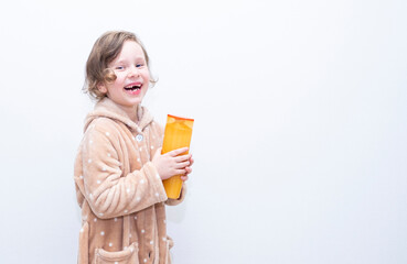 Child, Caucasian girl, with hair shampoo on the background of a gray wall. Copy space.