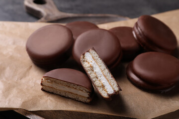 Tasty choco pies on parchment paper, closeup view