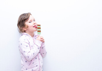 Caucasian girl eats frozen juice, ice cream and is very happy. Copy space.