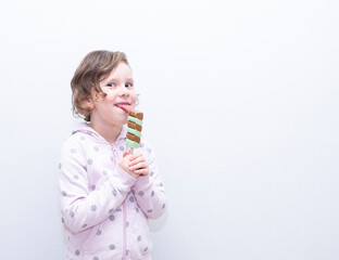 A child, a Caucasian girl, happily eats ice cream.