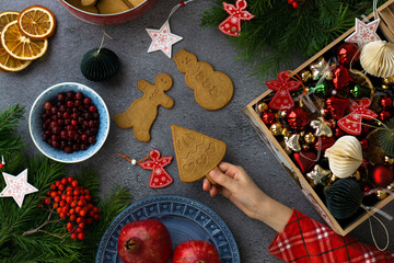 A child's pen holds cookies for the holiday. Festive background with Christmas cookies, cranberries, dried oranges, fruits, fir branches, Christmas toys.
