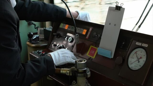Slow motion of train engine driver inside the Japanese local train cabin. Scenery along tracks railroad through window seen from driver room. Conductor drives a Japanese local tramway-Dan