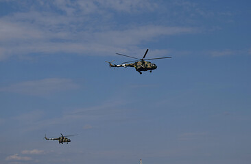 Two military helicopters in flight.