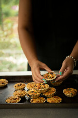 Woman's hand arranging tarts on a tray 