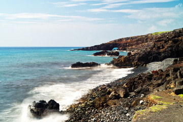 Naklejka na ściany i meble a lone river rock-strewn shoreline along Maui's Southeastern coastline. 