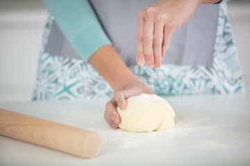 close up of hands kneading dough