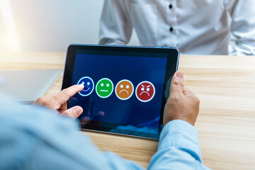 Human Resources. businessman hand putting smiley face rating on digital mobile tablet to review good rating, satisfaction research, digital marketing, good experience, customer feedback concept
