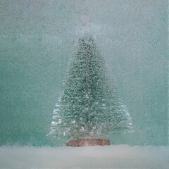 Surreal snowy Christmas tree with snow against pastel blue backgroud. Jungle futurism modern New...
