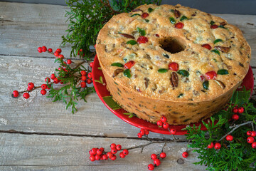 Traditional homemade fruitcake decorated with pecans and candied cherries.