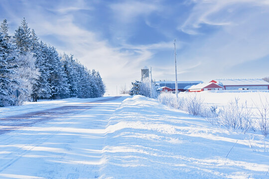 Snow covered road running through the farmland of rural Prince Edward Island, Canada.