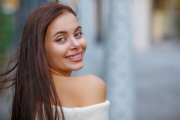 Beautiful Sexy Woman Wearing Fashionable Spring Or Fall Clothes  - White Warm Fluffy.  Model In Stylish Elegant Outfit Posing In Street Look In Camera. Copy, empty space for text. Blurred Details