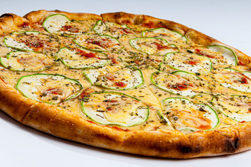 Zucchini pizza with garlic, topped with eggplant and tomato sauce on white background.