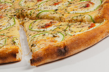 Zucchini pizza with garlic, topped with eggplant and tomato sauce on white background.