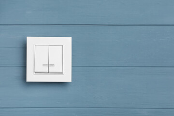 White light switch on grey wooden background. Space for text
