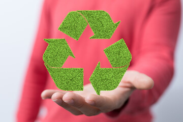 hand holding green recycle symbol