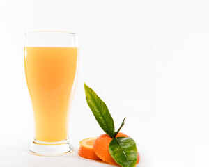 orange juice in glass with pieces of oranges and green leafs on black background. Summer and freshness concept.Copy Space