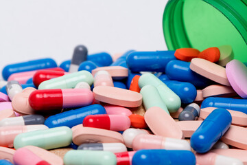 Medical pills and tablets spilling out of a drug bottle.