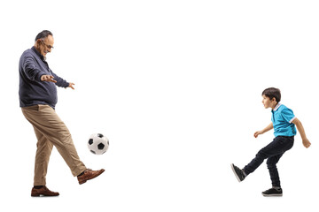 Full length profile shot of a grandfather and boy playing football