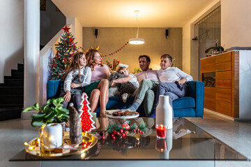 A happy family is sitting in a Christmas decorated living room