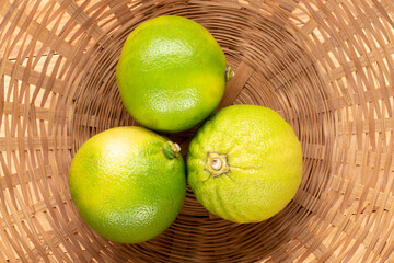 Three organic juicy bergamot on straw dishes, close-up, top view.
