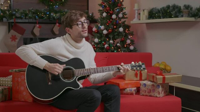 Man playing guitar singing Christmas songs 