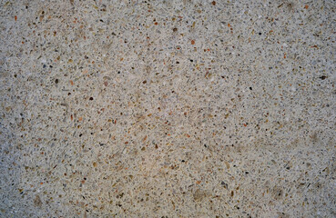 Abstract beige background interspersed with marble chips.