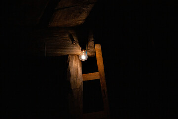 Light bulb shines bright at night against wood pole