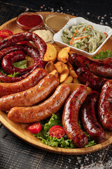 Closeup on assorted grilled sausages appetizer set on wooden board
