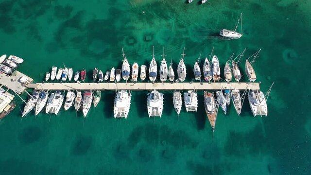 Aerial drone top down video of exotic island marina with emerald clear sea a safe anchorage for yachts and sailboats