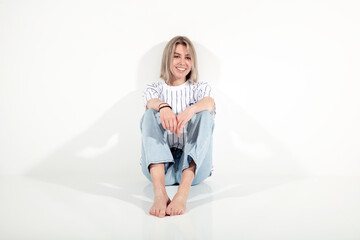Sportliches Model in Jeans am Boden sitzend Porträt