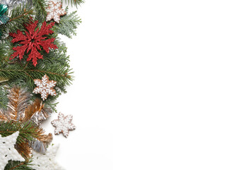 Christmas decoration. Christmas tree branches, red berries and snow flake shaped cookies on white background.