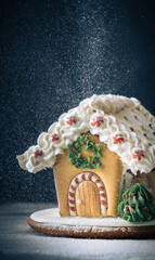 Christmas gingerbread house on the dark background with snowflakes falling down. Merry Christmas and Happy New Year 2022. Macro shot