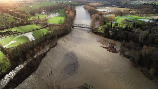 Drone Flying Over Bridge Crossing River to Rural Farmland Flooded in Fall